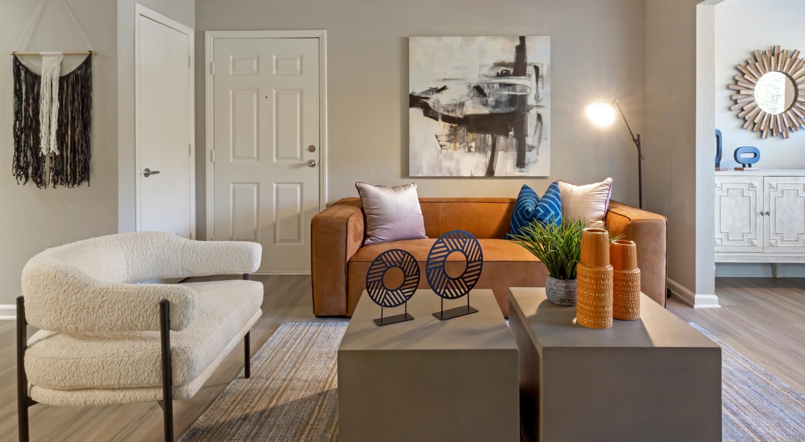 a living room with a couch, coffee table and a painting at The  Hargrove at Southpoint