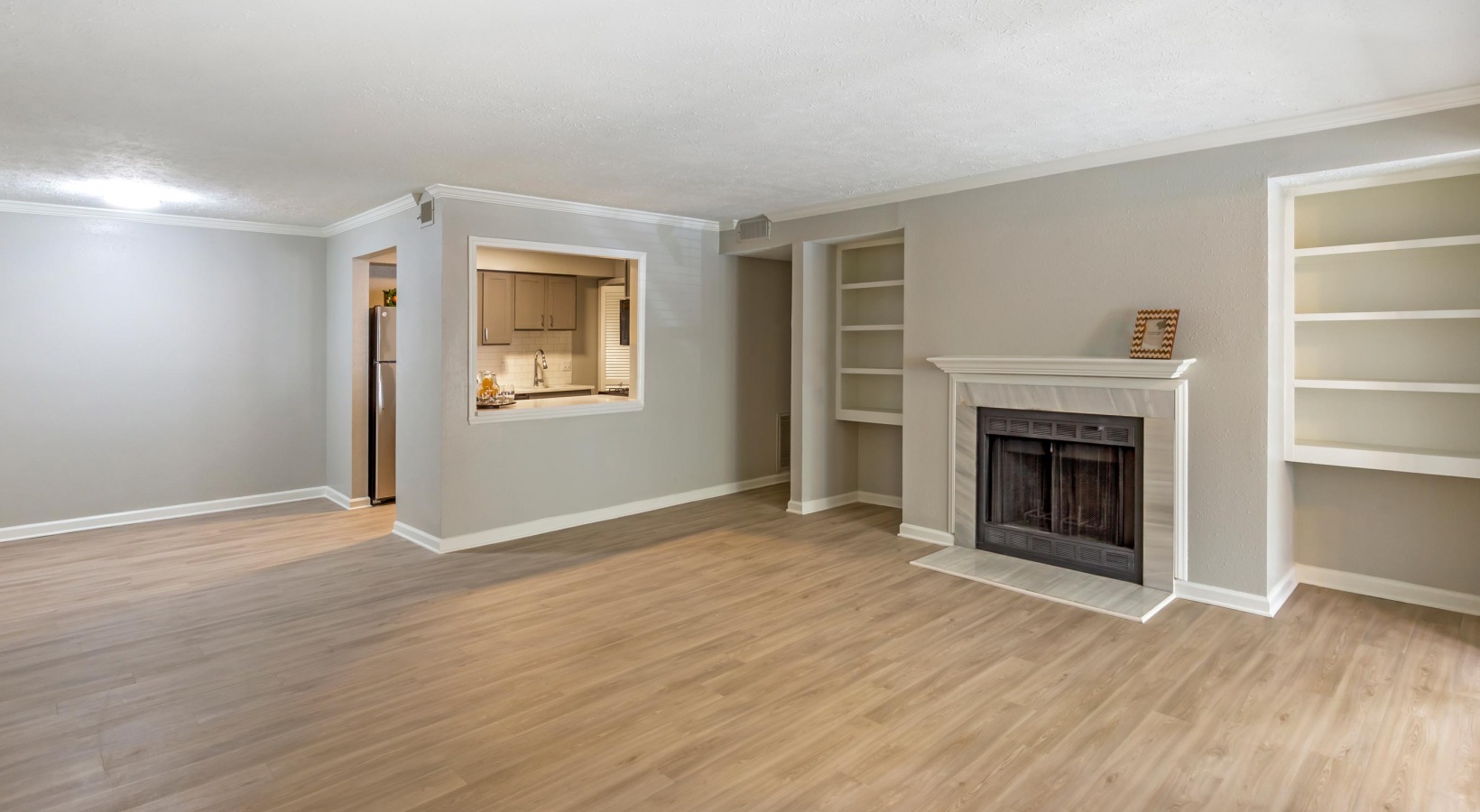 empty living room with hardwood floors and fireplace at The  Hargrove at Southpoint