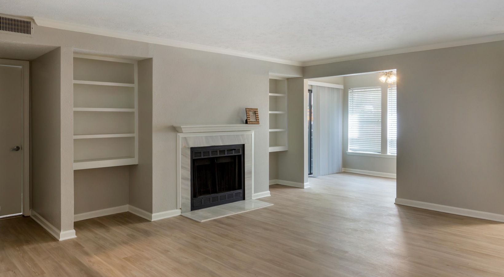 empty living room with fireplace and hardwood floors at The  Hargrove at Southpoint
