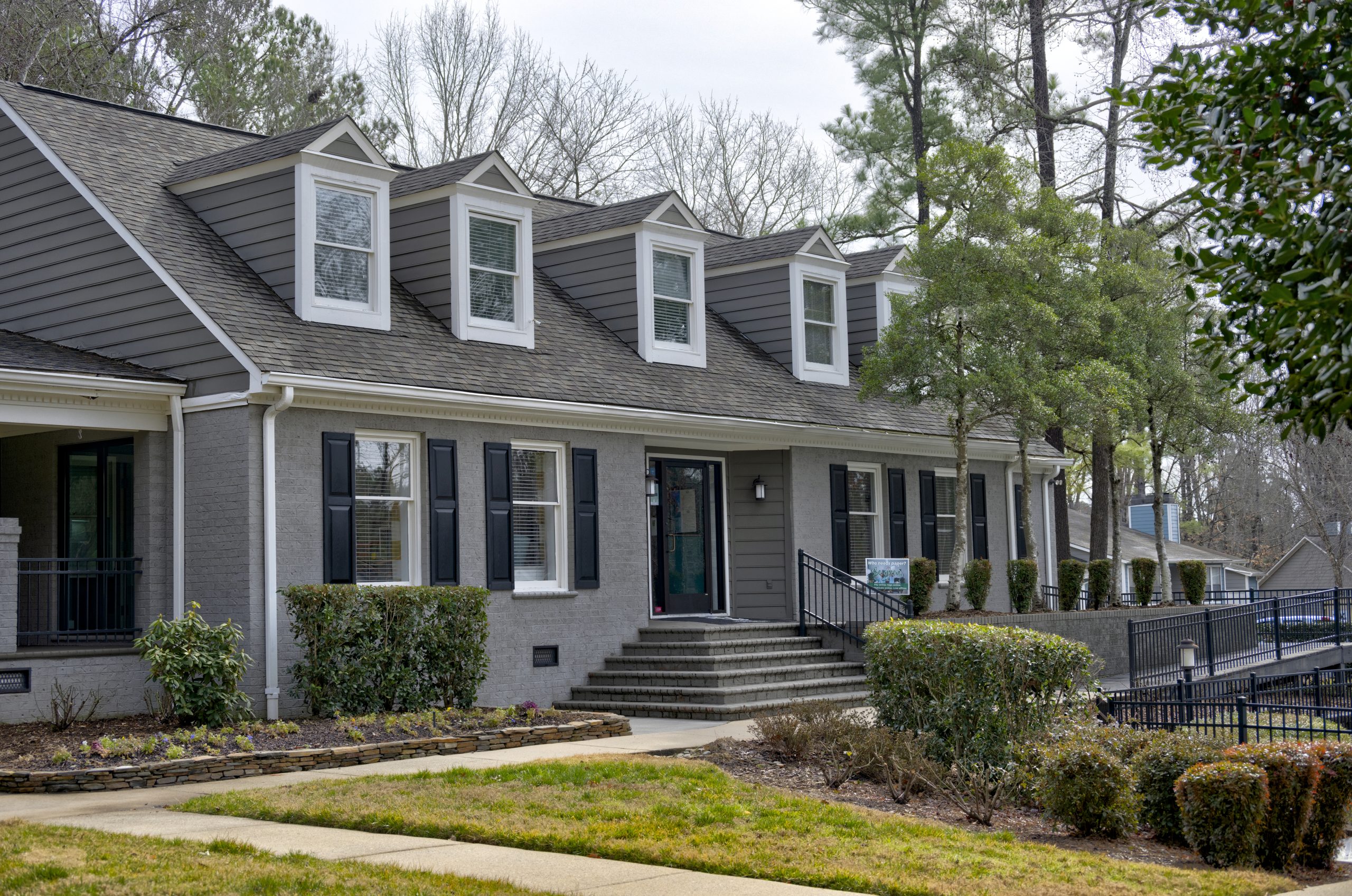 a gray house with black shutters and a front yard at The  Hargrove at Southpoint