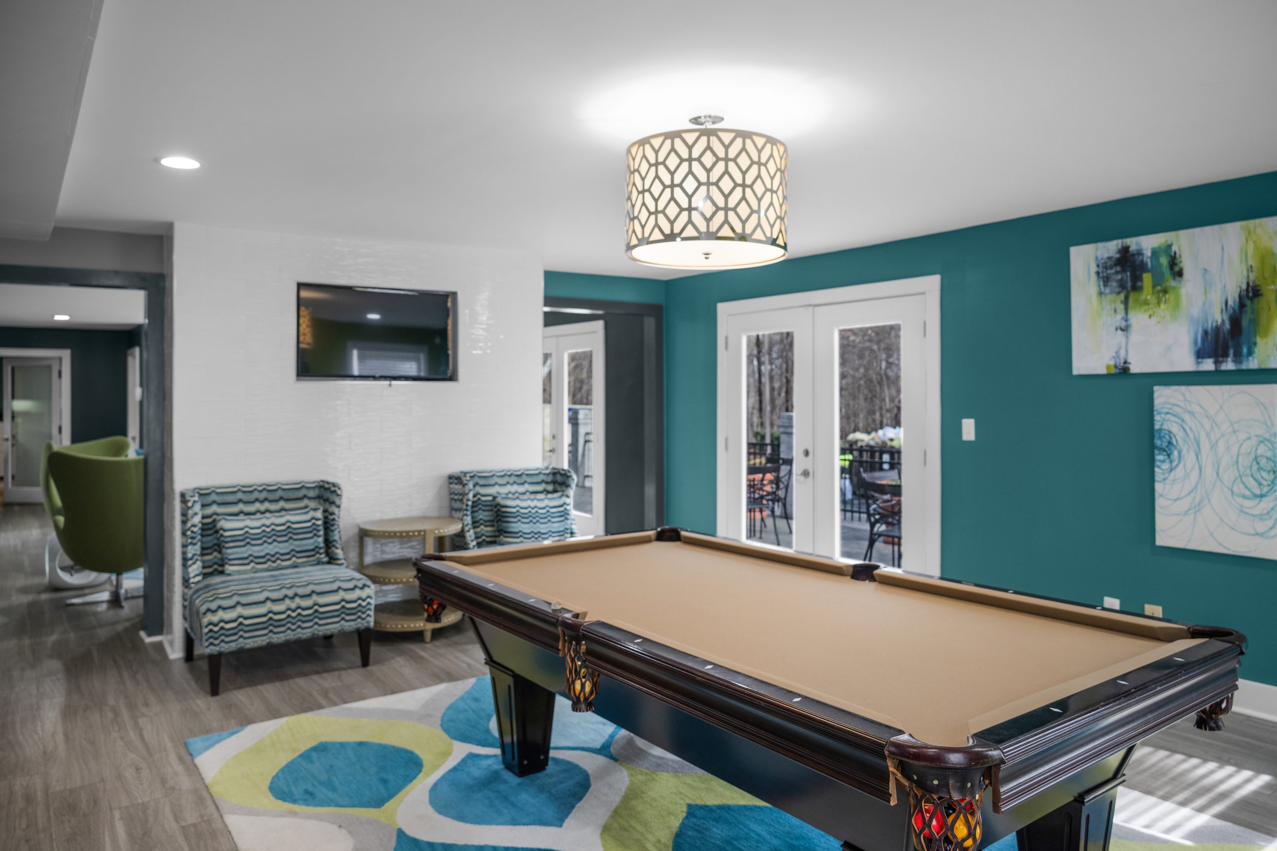 a pool table in a living room with blue walls at The  Hargrove at Southpoint
