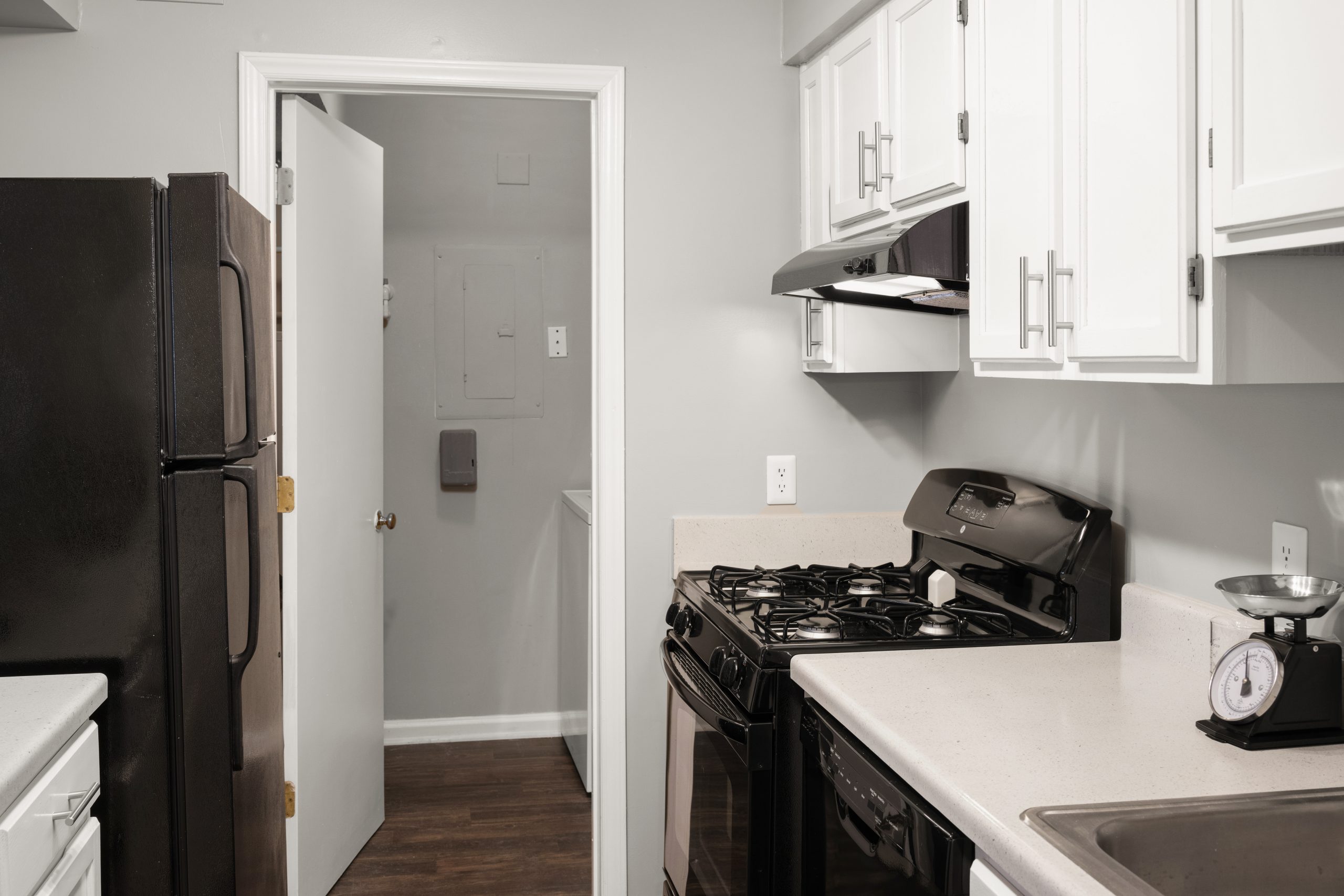 a kitchen with black appliances and white cabinets at The  Hargrove at Southpoint