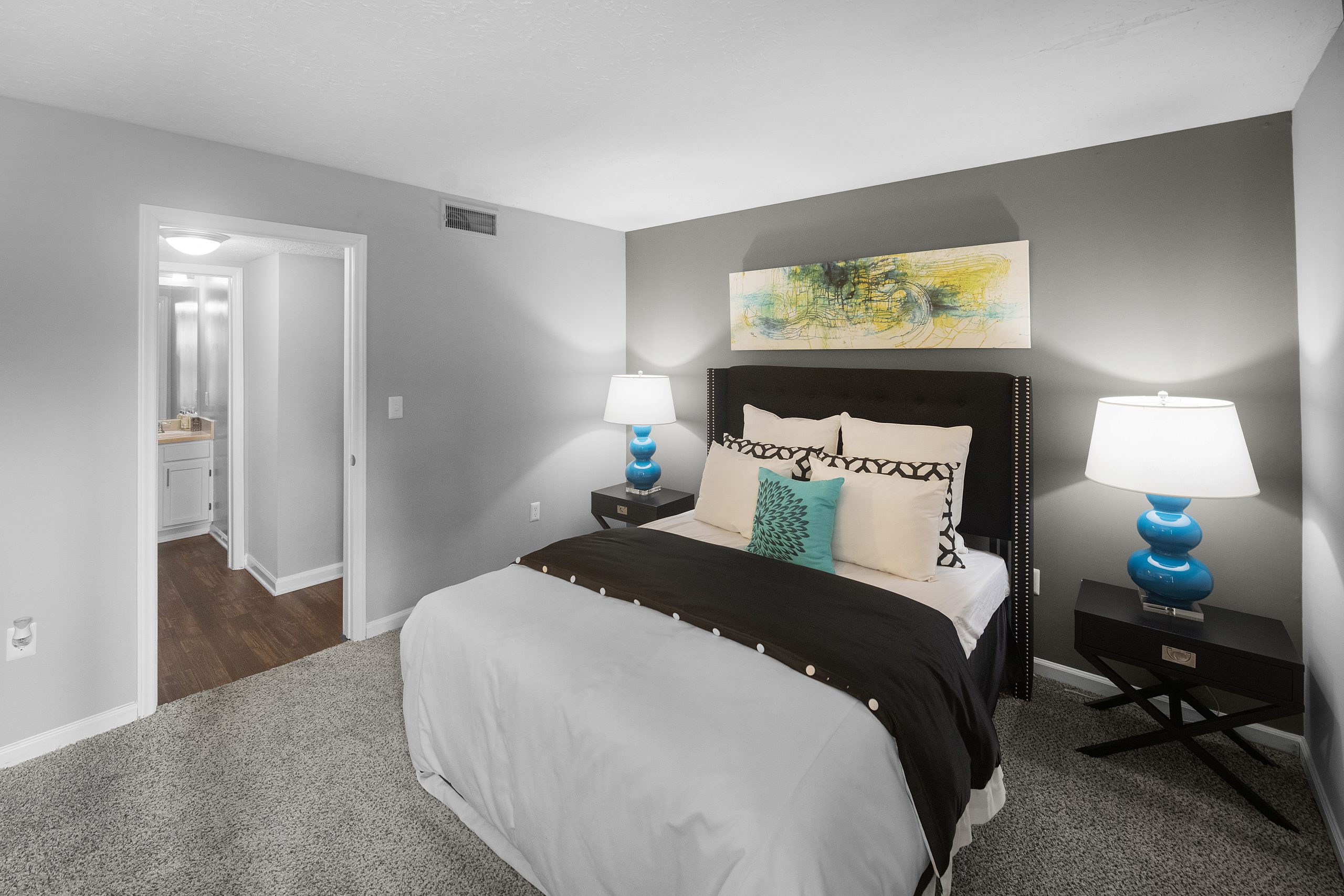 a bedroom with gray walls and a white bed at The  Hargrove at Southpoint