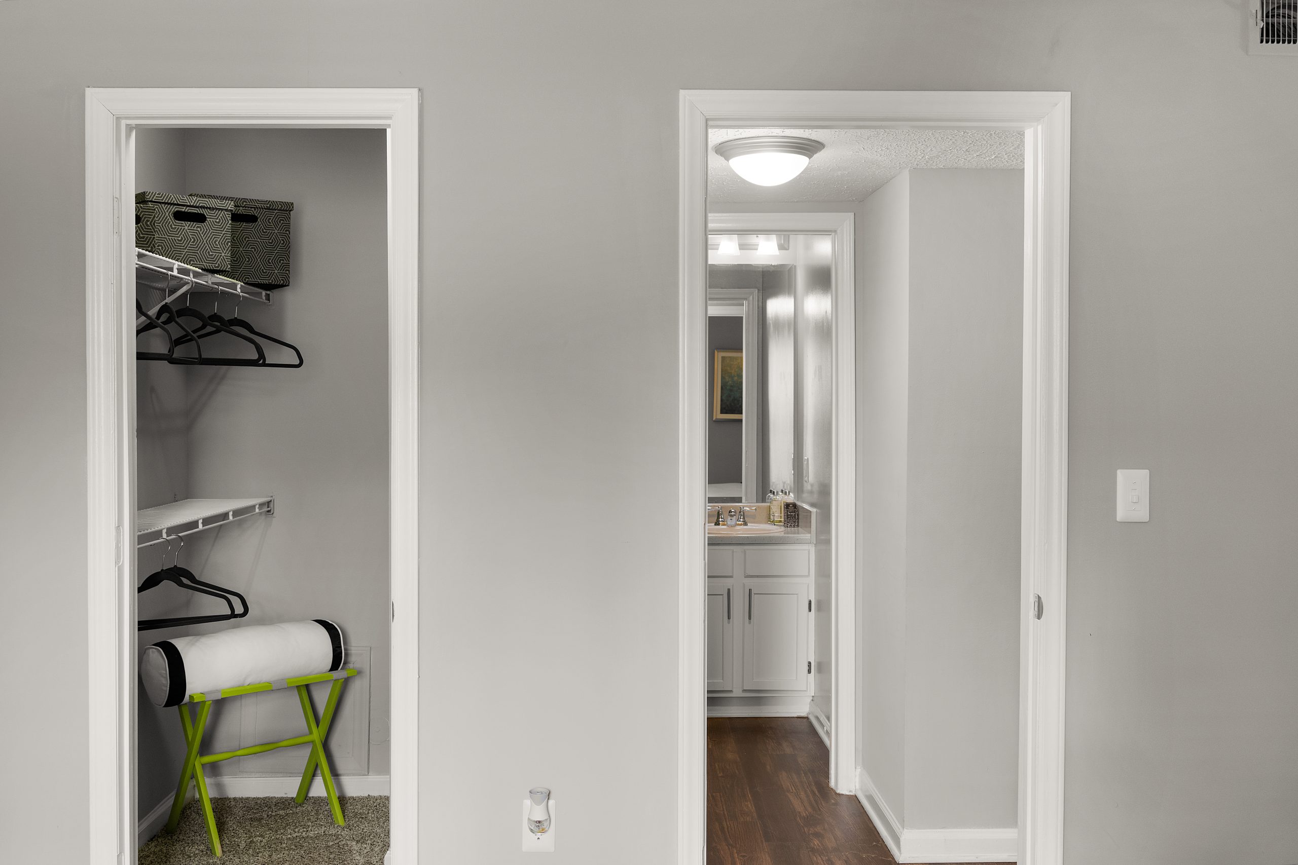 a hallway with a closet and a chair in it at The  Hargrove at Southpoint