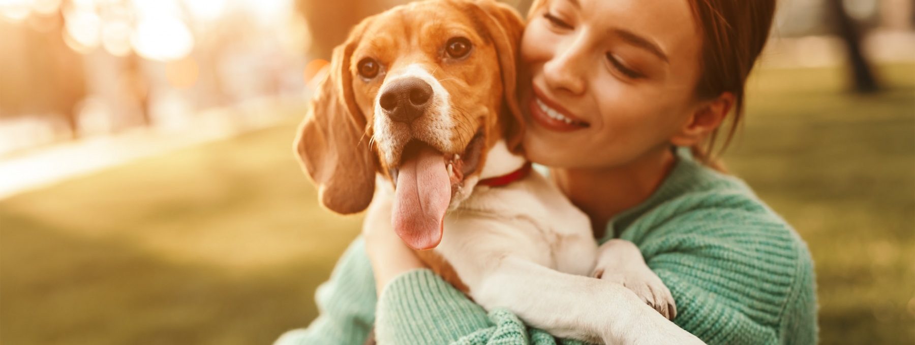 a woman holding a beagle in her arms at The  Hargrove at Southpoint