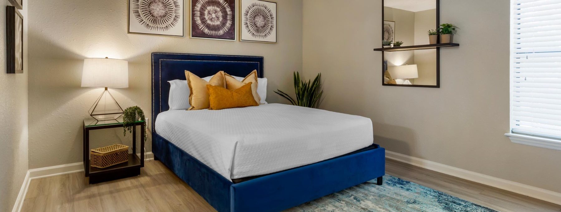 a bedroom with a blue bed and a nightstand at The  Hargrove at Southpoint