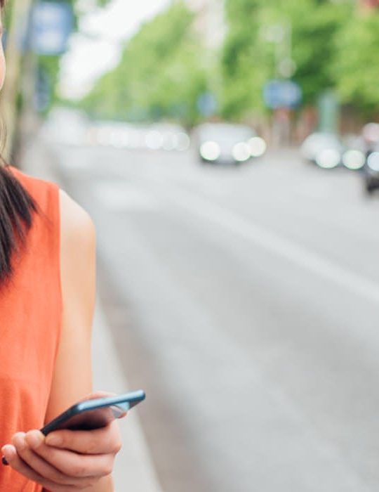 a woman is using her cell phone while walking down the street at The  Hargrove at Southpoint