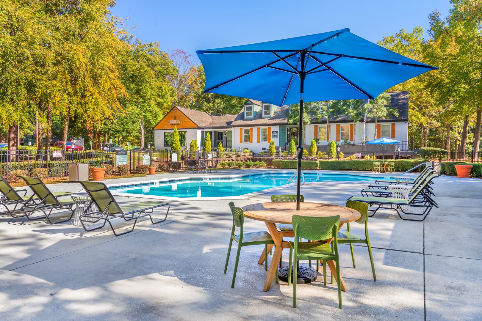 a pool with chairs and umbrellas near a patio at The  Hargrove at Southpoint