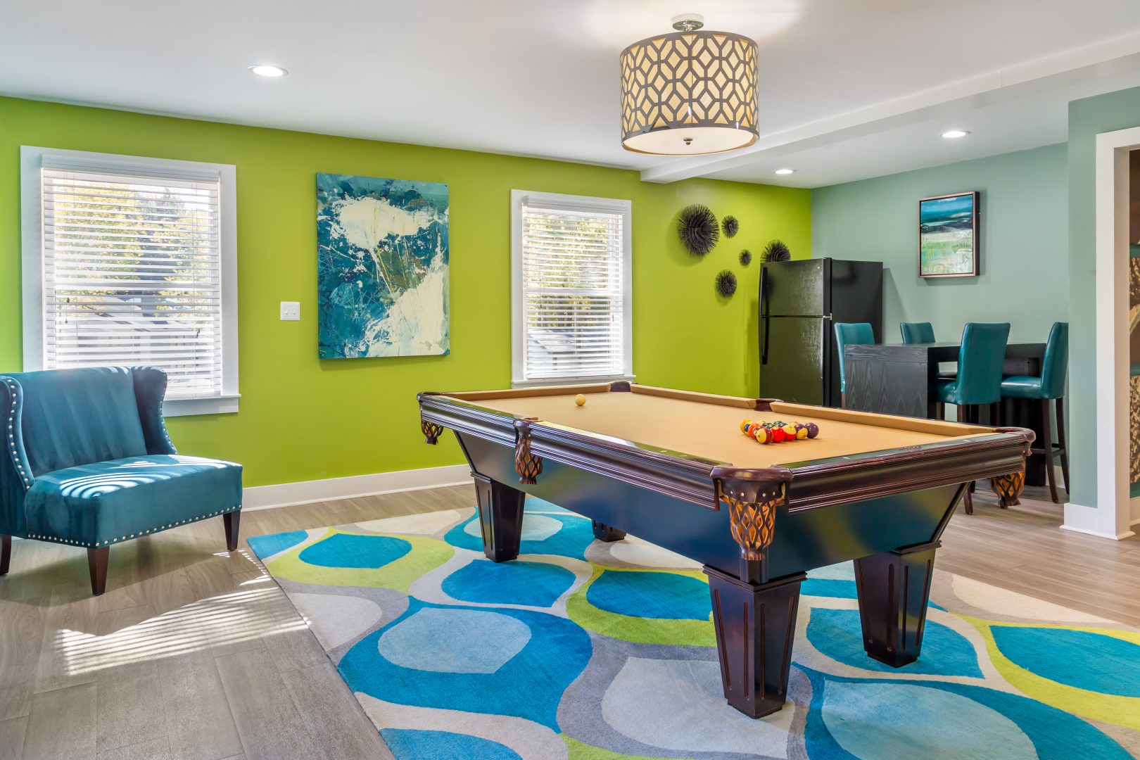 a pool table in a living room with green walls at The  Hargrove at Southpoint