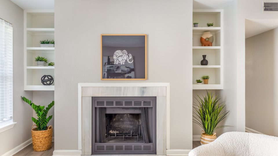 a fireplace in a living room with shelves and plants at The  Hargrove at Southpoint